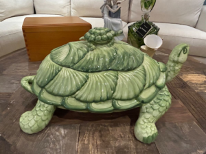 Large vintage green ceramic turtle tureen with a removable shell lid, detailed textured legs and head, displayed on a wooden table.
